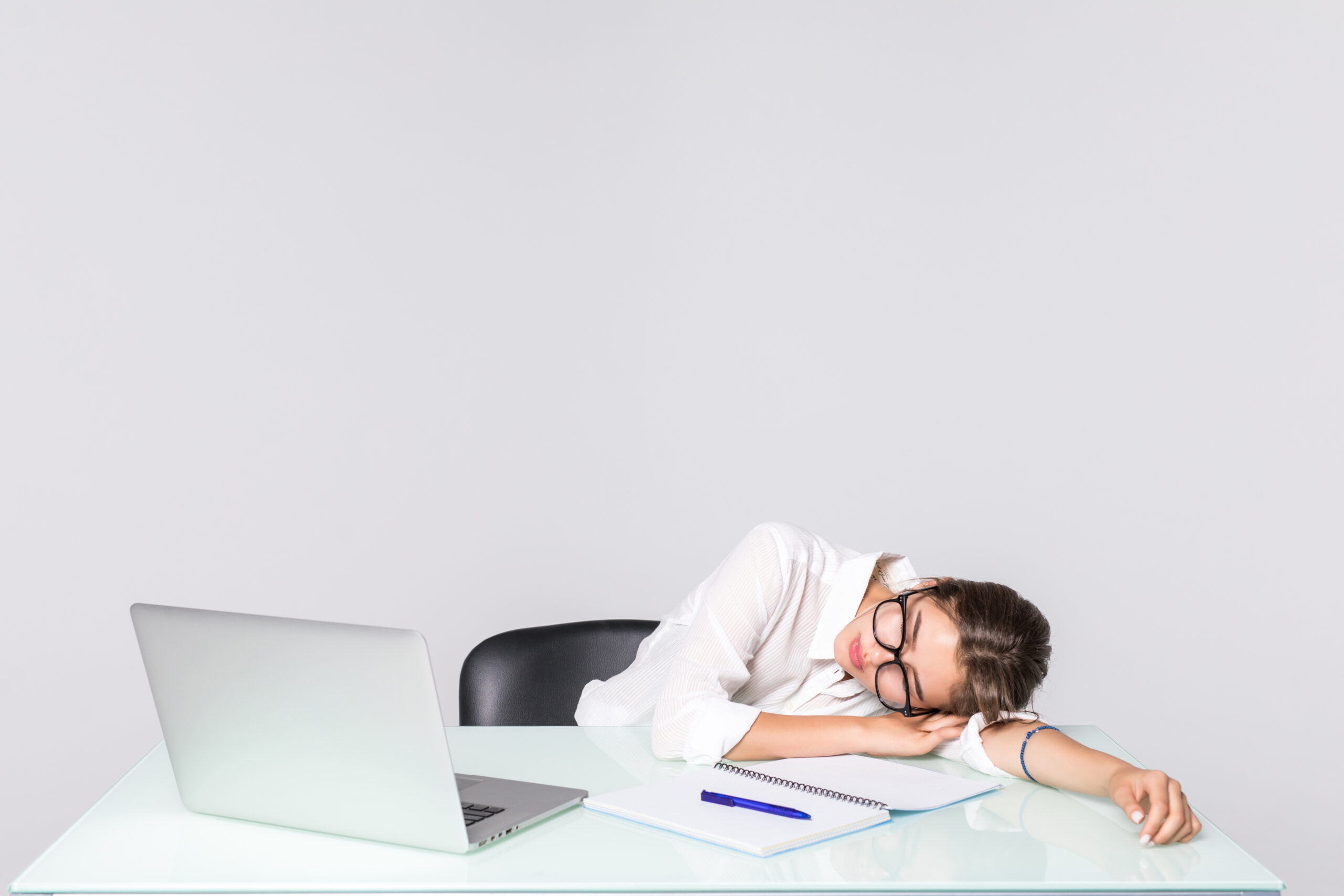 Business woman asleep at her desk isolated on white background